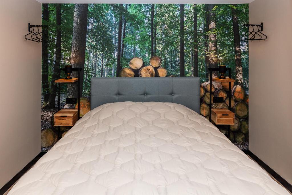 a bedroom with a bed in the woods at Comfortabel 2- persoons vakantiehuis nabij bos in Drenthe in Schoonoord