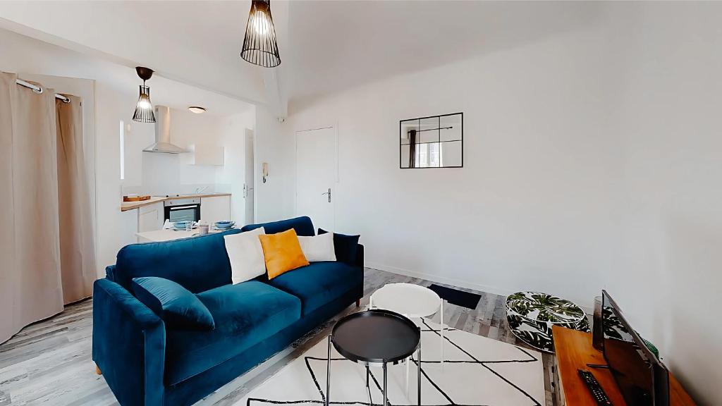 un salon avec un canapé bleu et une table dans l'établissement FLEGIER - St Charles Vieux Port, à Marseille