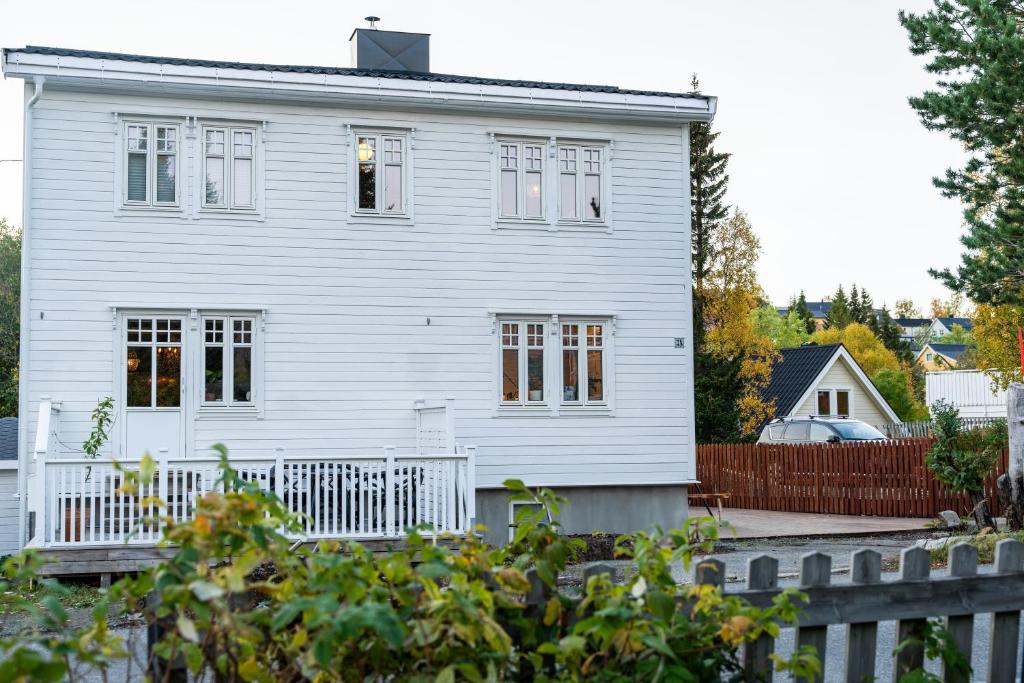 a white house with a fence in front of it at TROMSØ AURORA VILLA - Parking - Near Centrum in Tromsø