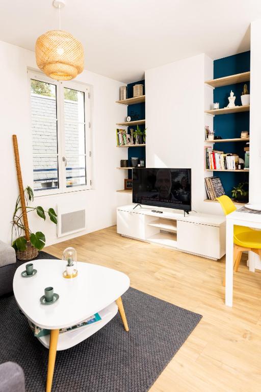 un salon avec une table basse et une télévision dans l'établissement Le Charmant Amboisien - Centre, à Amboise