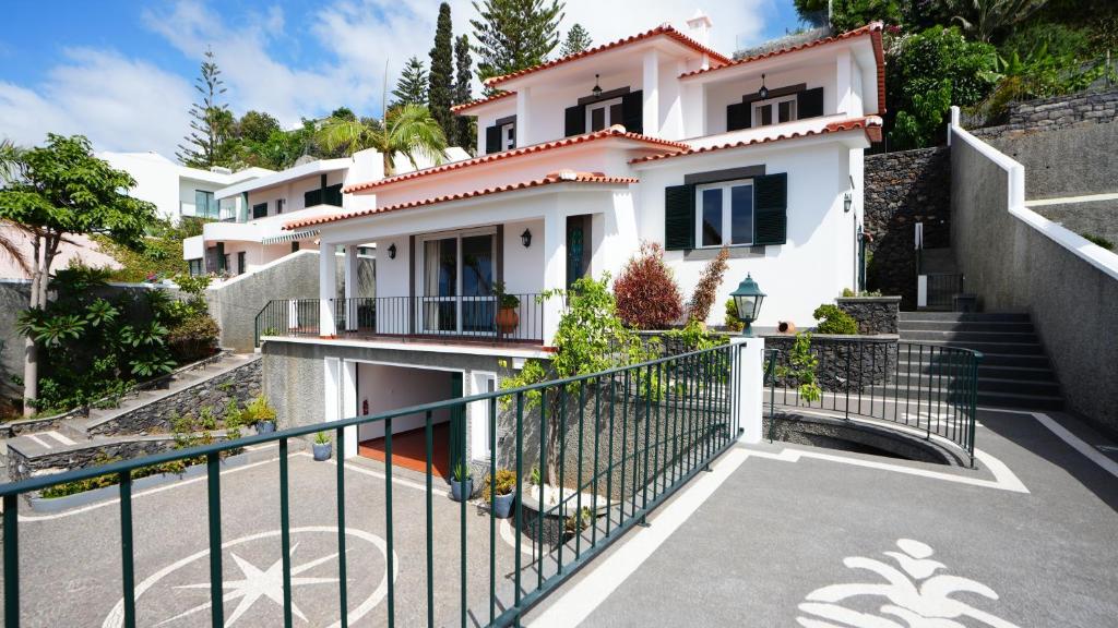 a white house with a staircase in front of it at NostraCasa by LovelyStay in Caniço