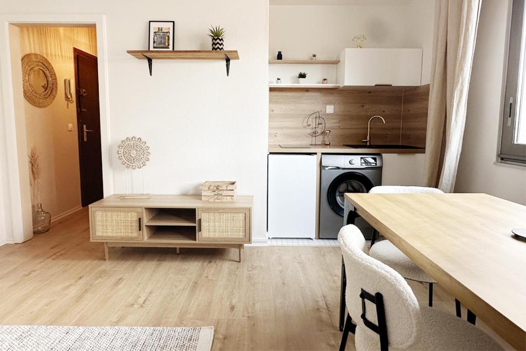 une cuisine avec une table, une cuisinière et un lave-vaisselle dans l'établissement Le nid - studio, à Strasbourg