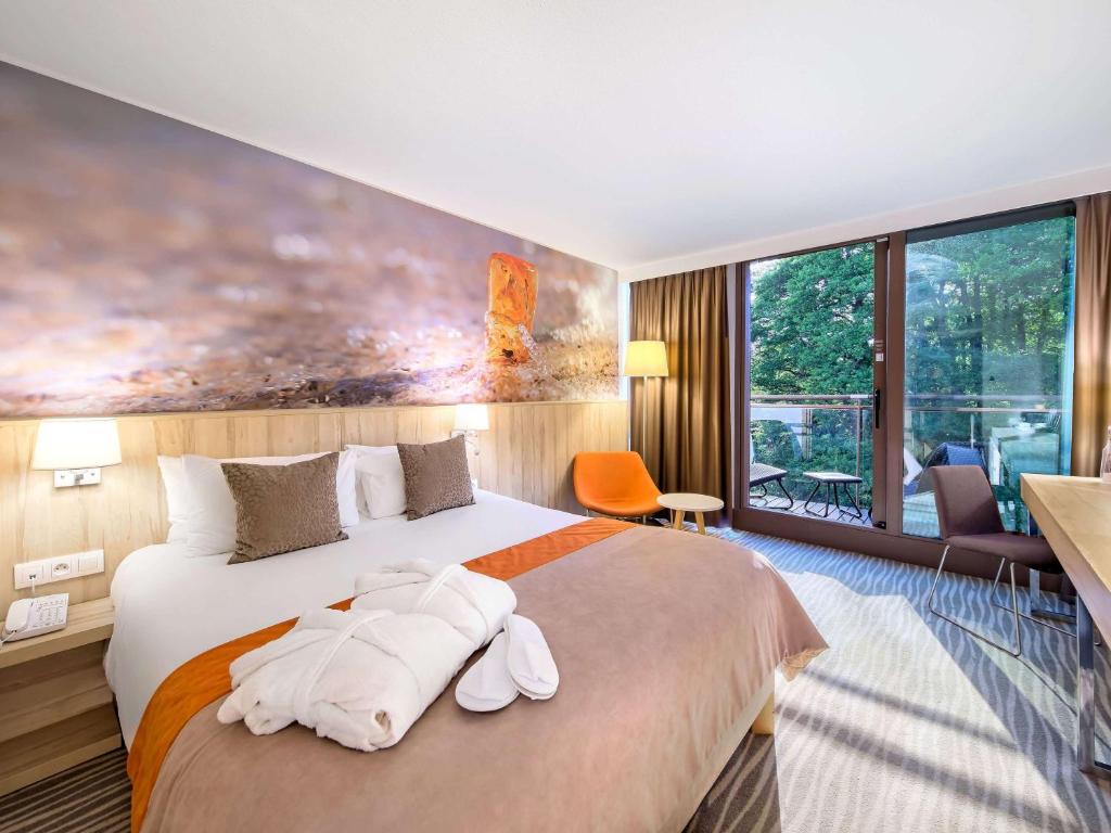 a hotel room with a bed with towels on it at Mercure Gdańsk Posejdon in Gdańsk