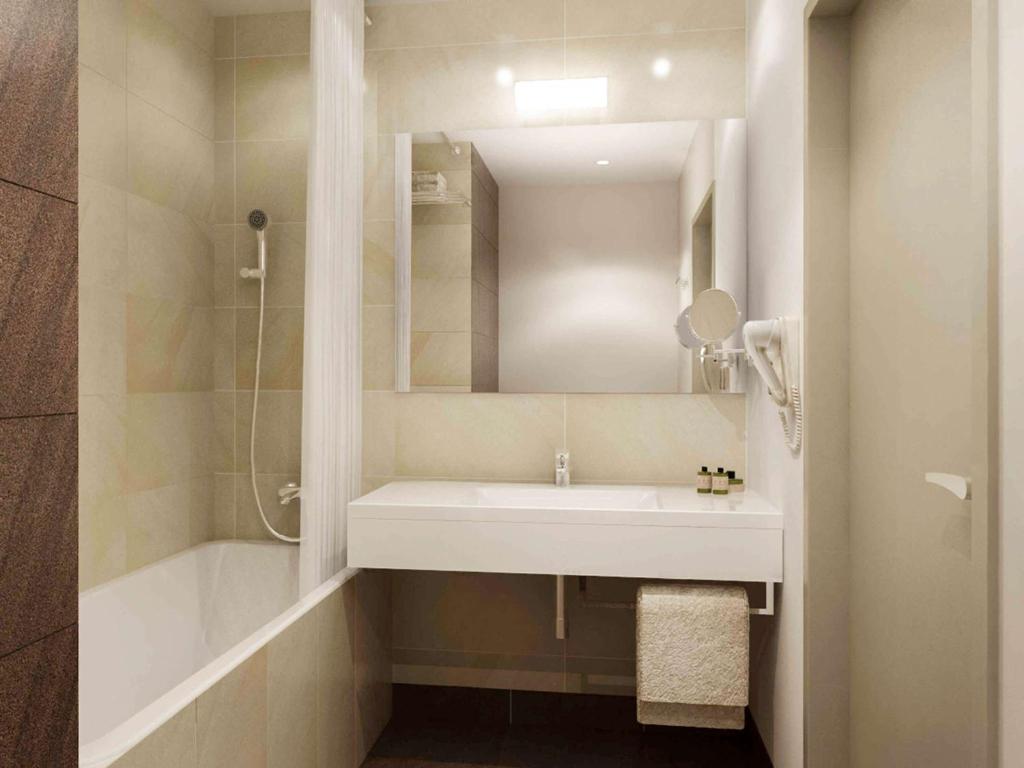 a bathroom with a white sink and a shower at Mercure Gdańsk Posejdon in Gdańsk