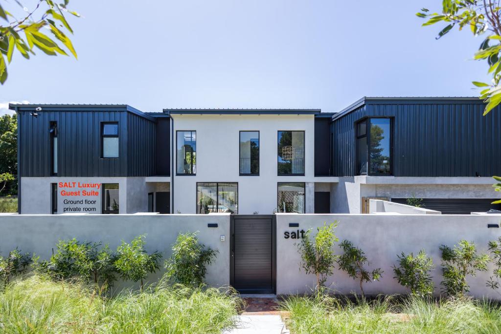 an exterior view of a house with black and white at SALT Luxury Guest Suite Plett in Plettenberg Bay