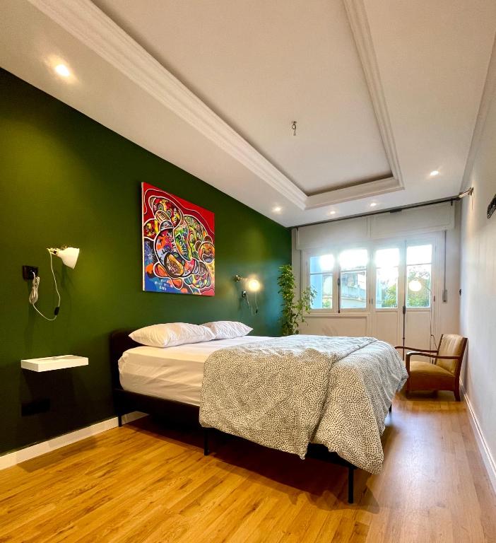 a bedroom with a bed with a green wall at Emeralds House in Tangier