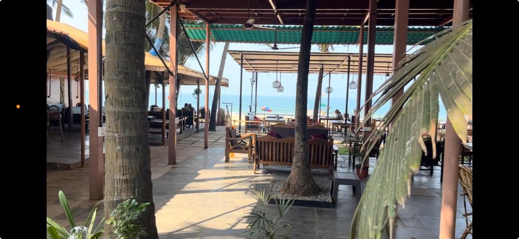 a restaurant with tables and chairs on the beach at Jardim a Mar in Agonda