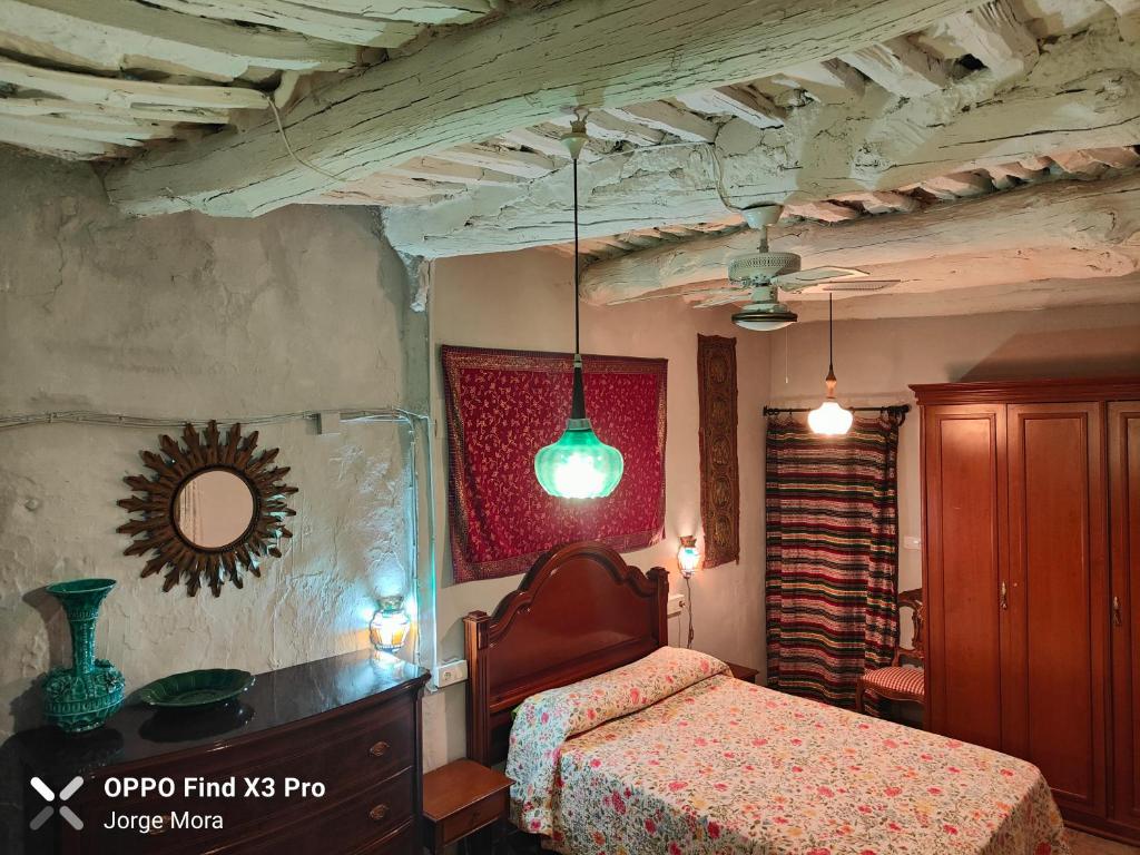 a bedroom with a bed and a mirror on the wall at La casa de Paco y Ana in Pitres
