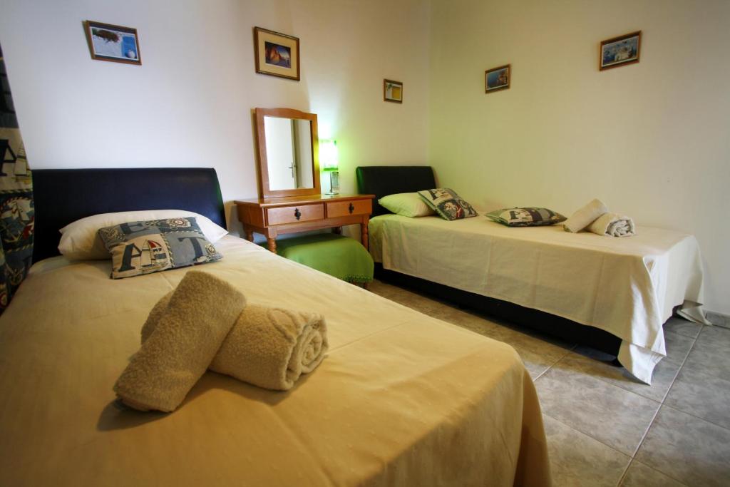 a hotel room with two beds and a mirror at Pissouri Beach Apartments in Pissouri
