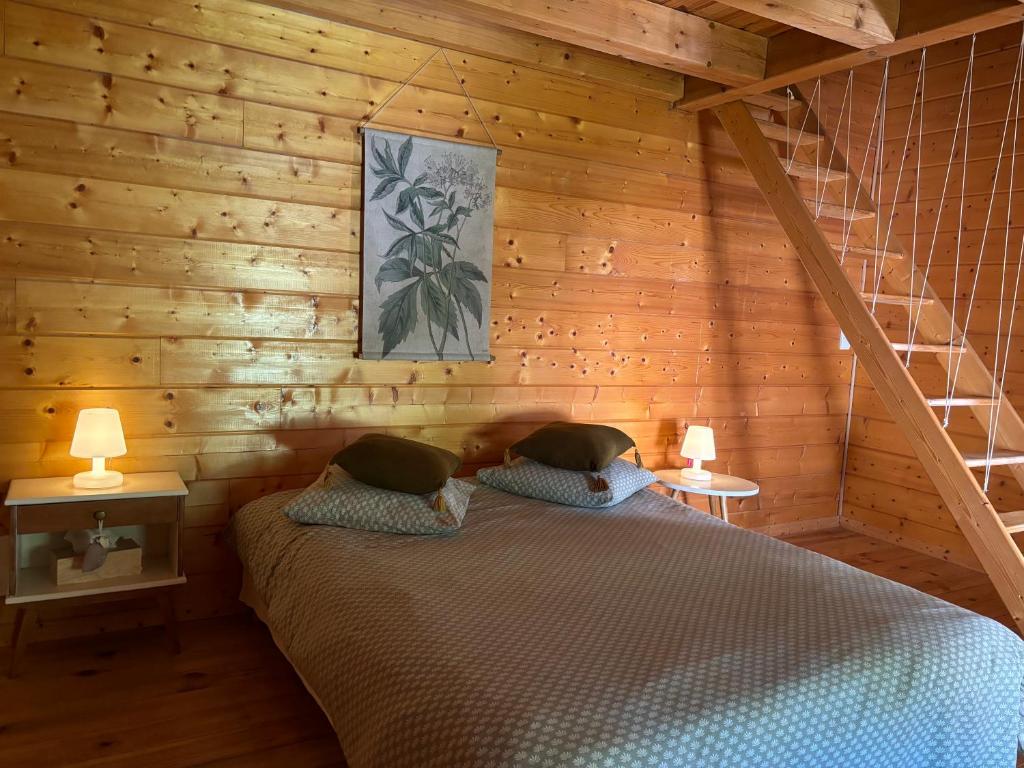 une chambre avec un lit dans une pièce en bois dans l'établissement Gîte Au Pradin en pleine nature, à Saint-Bresson
