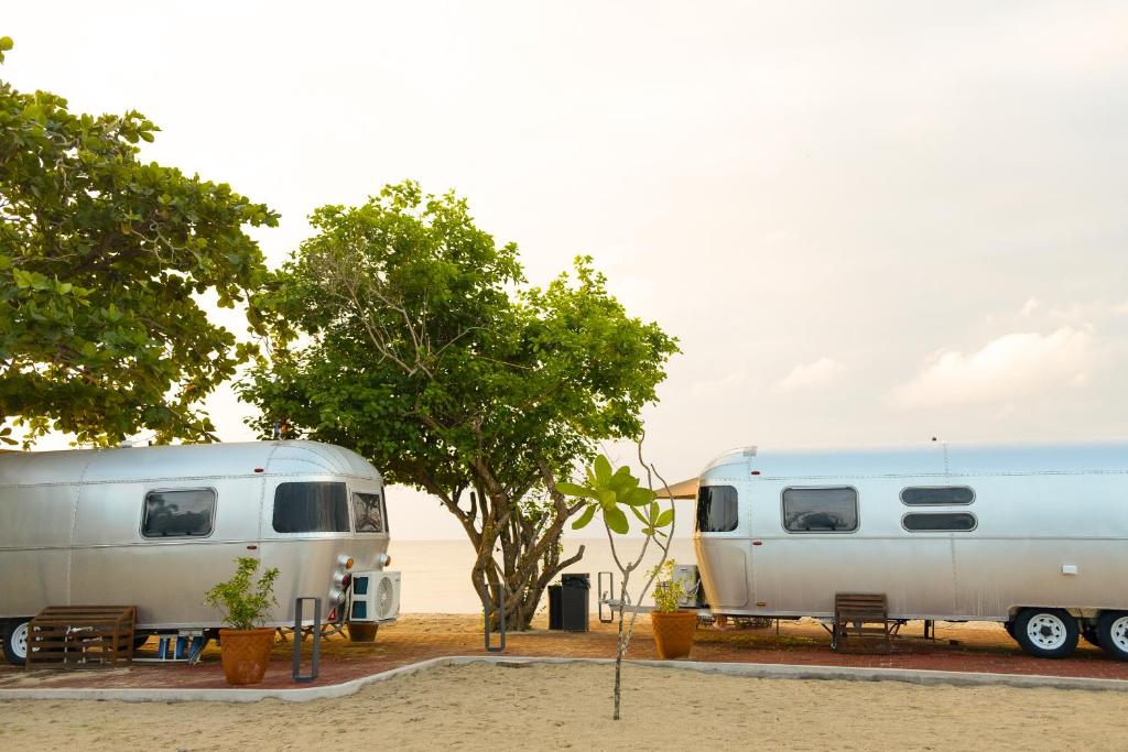 two trailers are parked next to a tree at Camperisti Club Laiya in San Juan