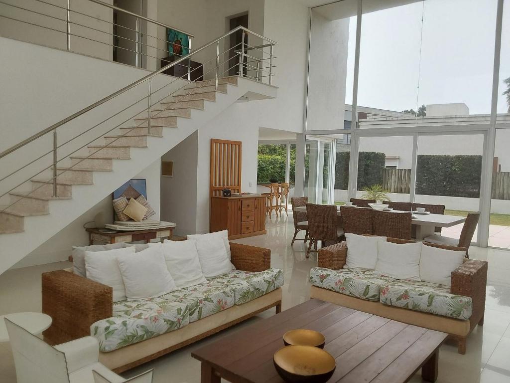 ein Wohnzimmer mit einer Couch und einer Treppe in der Unterkunft Casa de Verão no Condomínio Porto Coronado in Xangri-lá