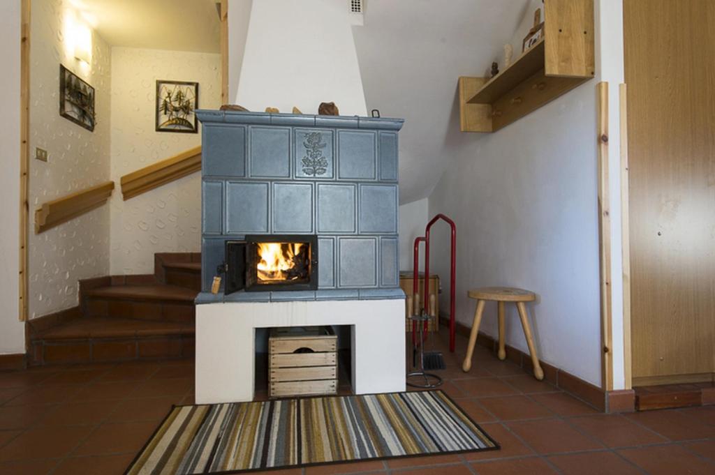 a fireplace in the middle of a room at Villa Tamion in Vigo di Fassa