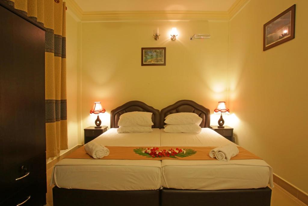 Un dormitorio con una cama con toallas y flores. en Hanifaru Transit Inn, en Dharavandhoo