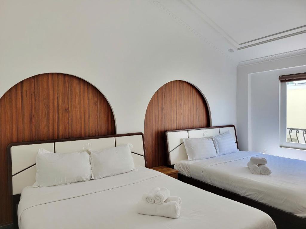 Postel nebo postele na pokoji v ubytování Savio Hotel Trieu Viet Vuong