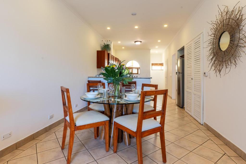 una cucina e una sala da pranzo con tavolo e sedie di Sunrise 42 - 2 Bedroom Ocean View Condo a Tamarindo