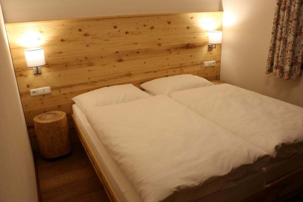 sypialnia z białym łóżkiem z 2 lampami w obiekcie Ferienwohnungen Falch Simone w mieście Sankt Anton am Arlberg