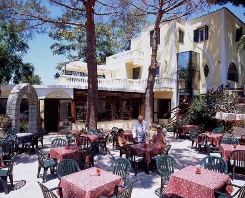 un gruppo di tavoli e sedie di fronte a un edificio di Albergo Villa Hibiscus a Ischia