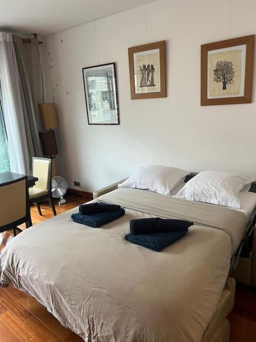 Un pat sau paturi într-o cameră la Suite avec balcon vue Tour Eiffel