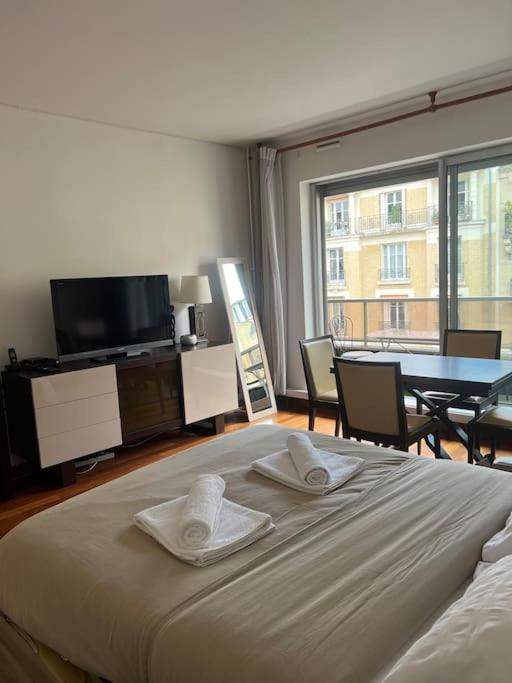 Un pat sau paturi într-o cameră la Suite avec balcon vue Tour Eiffel