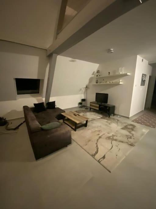 un salon avec un canapé et une table dans l'établissement Appartement tranquille, à Luttenbach-près-Munster