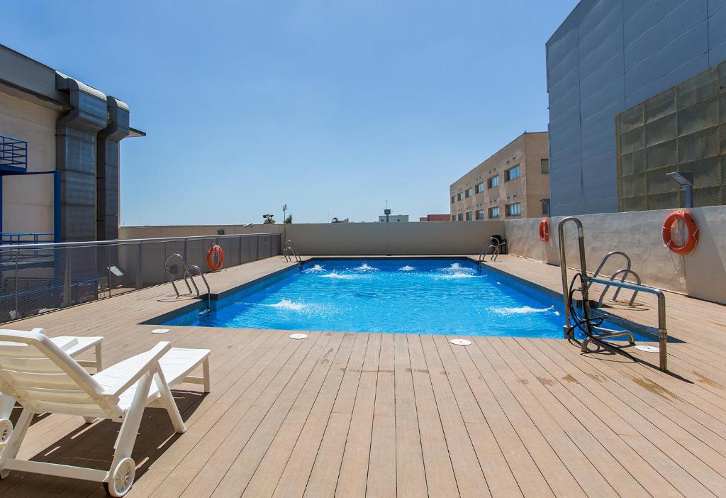 a swimming pool on the roof of a building at Áticos Lux Sevilla Piscina Parking in Bormujos