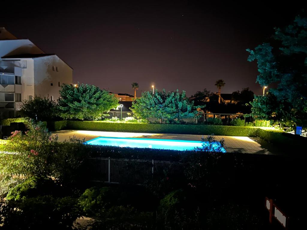 une piscine dans une cour la nuit dans l'établissement Magnifique appartement grau du roi, au Grau-du-Roi