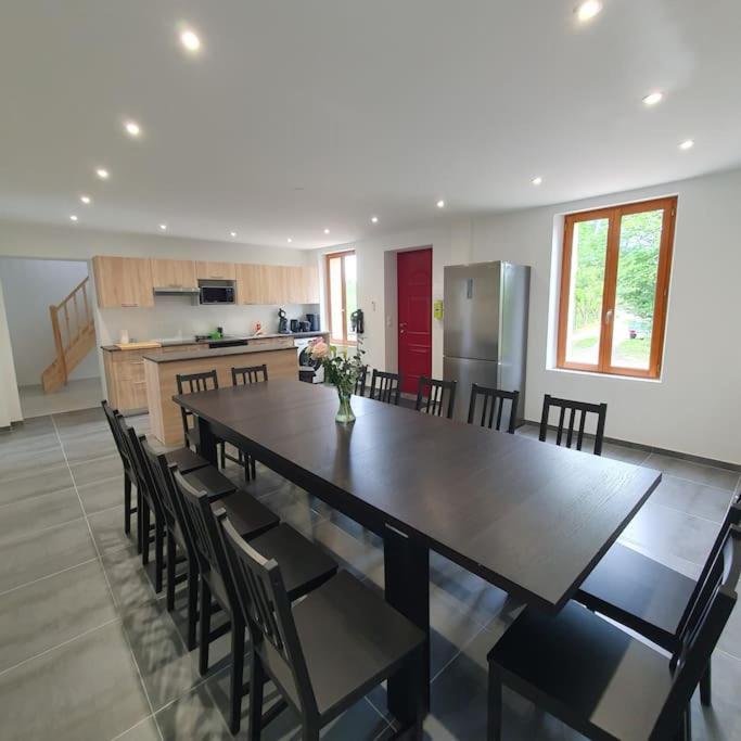 une grande salle à manger avec une grande table et des chaises dans l'établissement Maison des retrouvailles, à Bressolles