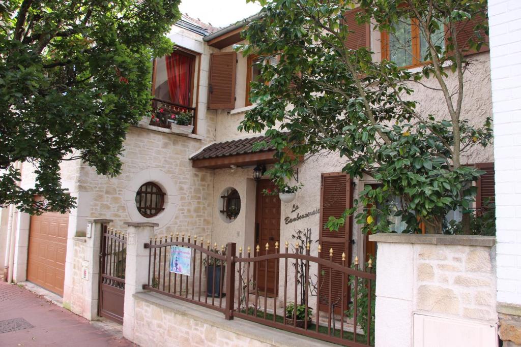 a house with a fence and trees on a street at La bambouseraie in Montrouge