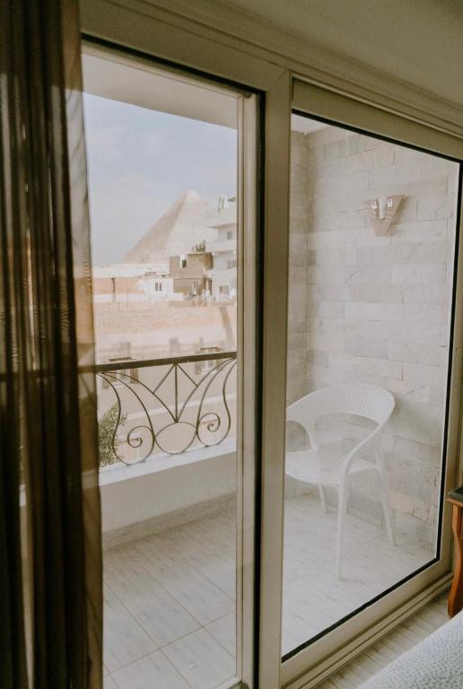 a sliding glass door with a view of a balcony at Jimmy Pyramids Hotel in Cairo
