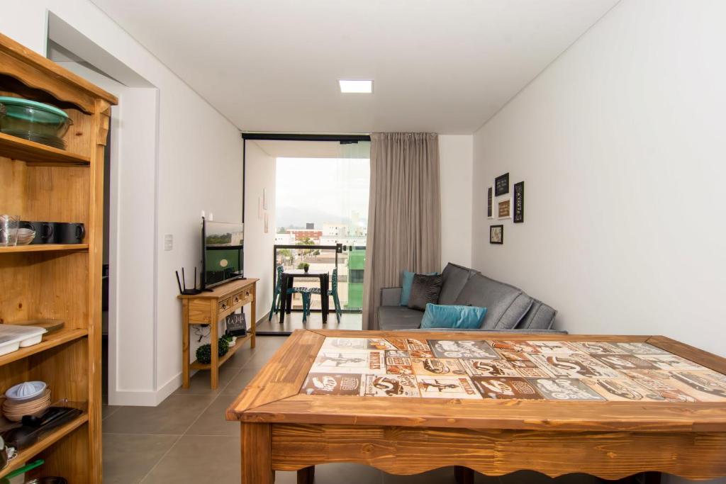 ein Wohnzimmer mit Tisch und Couch in der Unterkunft Ótima localização, Apto NOVO no Bay Village KQ8551 in Balneário Camboriú