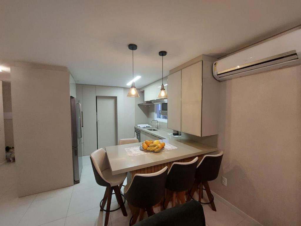 eine Küche mit Tisch und Stühlen in einem Zimmer in der Unterkunft Belo Apartamento no Centro de Capão da Canoa in Capão da Canoa