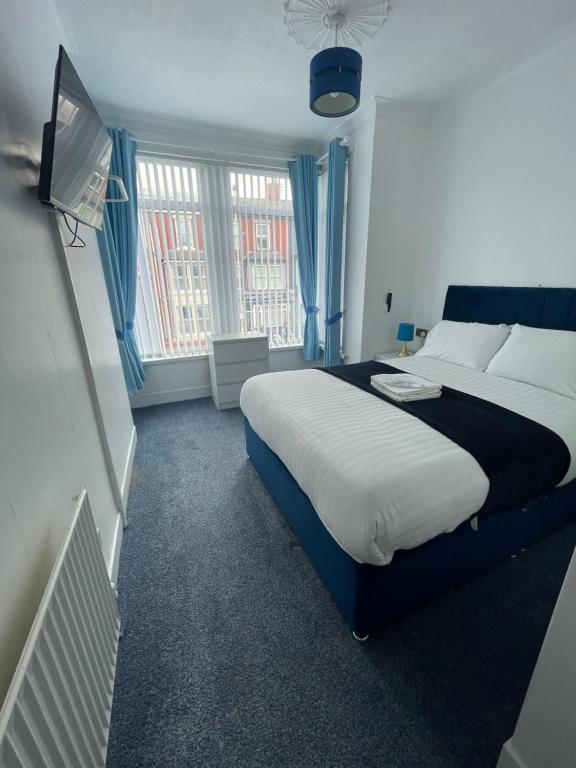 a bedroom with a large bed and a television at The New ATLAS HOTEL in Blackpool
