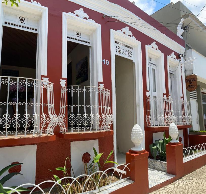 a red and white building with balconies and plants at Pousada da Orla in Itacaré