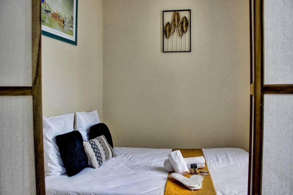 a bedroom with a bed with white sheets and pillows at Appartement PONTAILLAC- ROYAN in Pontaillac