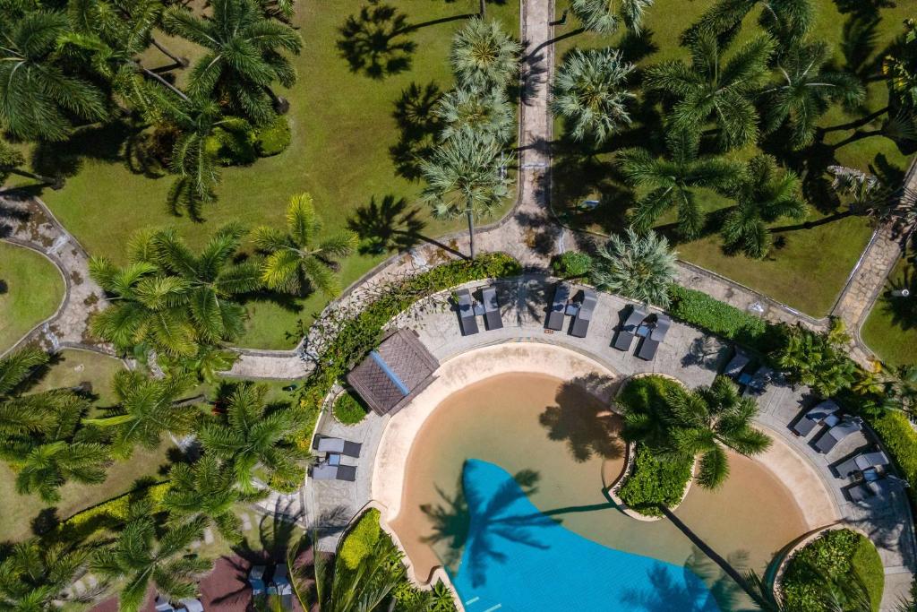 an overhead view of a pool in a park with palm trees at Phuket Marriott Resort & Spa, Merlin Beach in Patong Beach