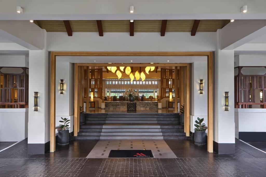 a lobby of a building with a staircase leading into a building at Phuket Marriott Resort & Spa, Merlin Beach in Patong Beach