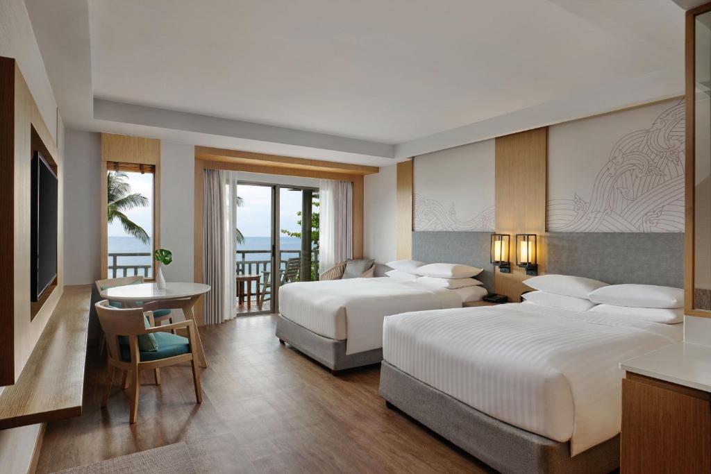 a hotel room with two beds and a balcony at Phuket Marriott Resort & Spa, Merlin Beach in Patong Beach