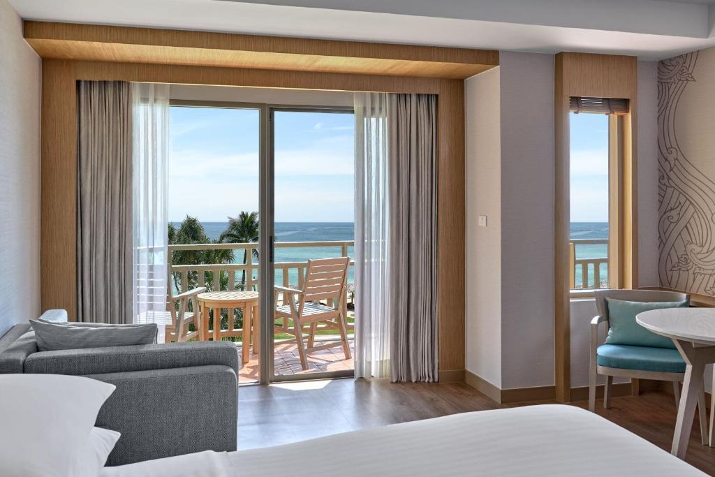 a hotel room with a bed and a view of the ocean at Phuket Marriott Resort & Spa, Merlin Beach in Patong Beach