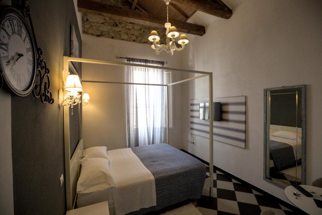 Un dormitorio con una cama y un reloj en la pared. en Manì Rooms, en Cagliari