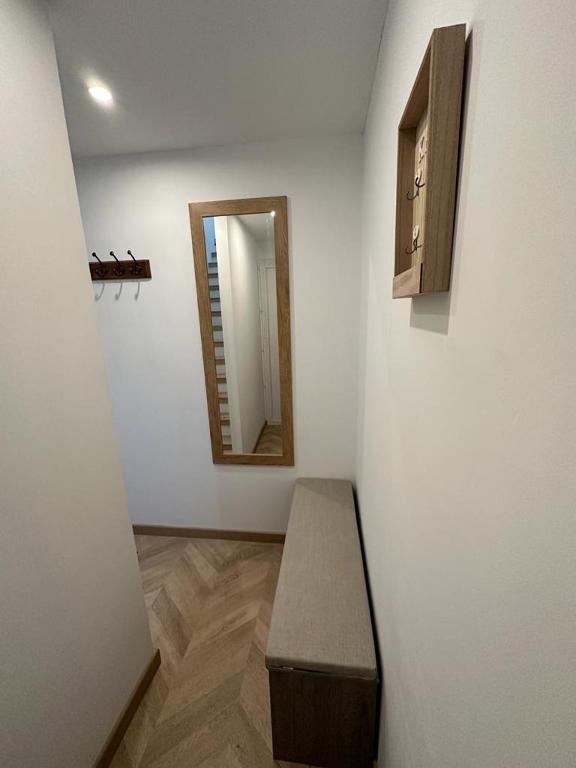 Cette chambre comprend un banc et un miroir mural. dans l'établissement Appart cosy - belle vue, à Niort
