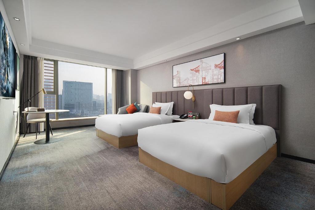 Postel nebo postele na pokoji v ubytování Mehood Lestie International Hotel Linhexi Guangzhou East Railway Station Branch - Free Shuttle Bus to Canton Fair Complex During Canton Fair Period & Free afternoon tea & Free midnight snack & Free VPN Internet Access