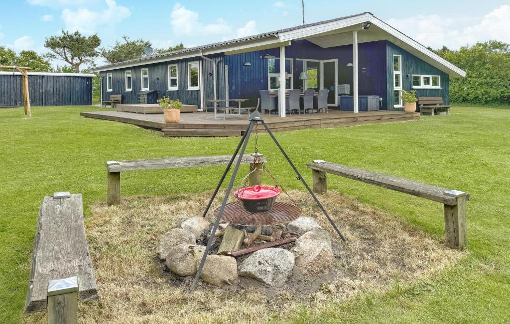 une maison avec un pot sur le feu dans une cour dans l'établissement Holiday Home Gyvelvænget Glesborg Ii, à Fjellerup Strand