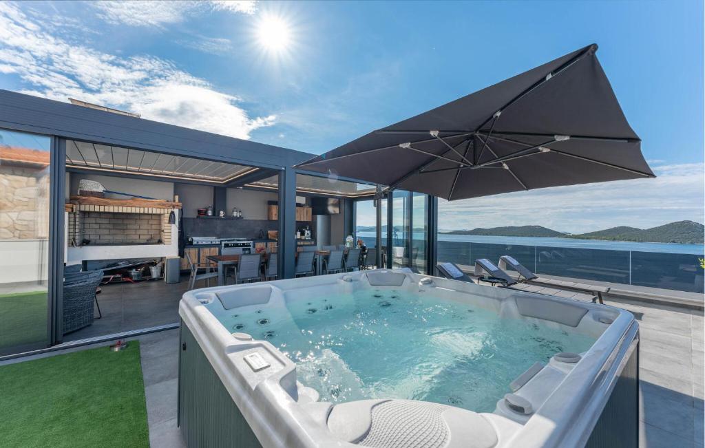 a hot tub on a patio with an umbrella at Lovely Apartment In Drage With Sauna in Drage