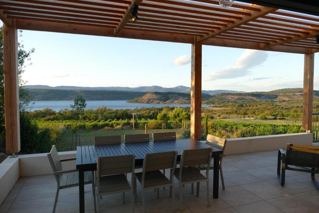 une salle à manger avec une table et des chaises et une vue dans l'établissement Les Terrasses du Salagou - Superbe vue sur le lac, à Liausson