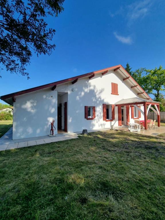 une petite maison blanche avec une grande cour dans l'établissement Airial landais, à Sanguinet