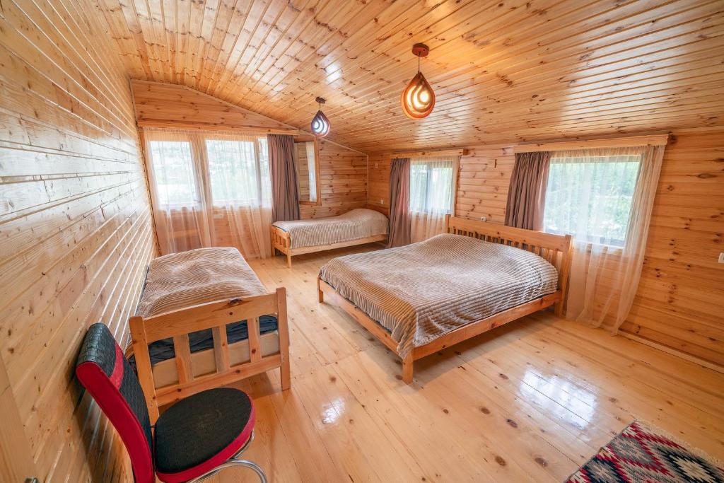 una camera con 2 letti in una baita di tronchi di Ioane's Chalet a Mestia
