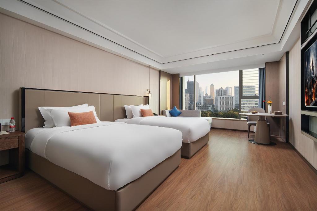 Postel nebo postele na pokoji v ubytování Mehood Lestie International Hotel Linhexi Guangzhou East Railway Station Branch - Free Shuttle Bus to Canton Fair Complex During Canton Fair Period & Free afternoon tea & Free midnight snack & Free VPN Internet Access