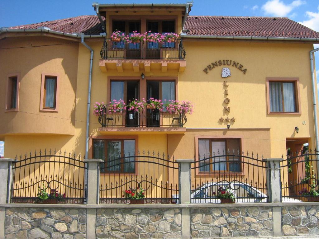 un bâtiment avec des boîtes de fleurs sur les balcons dans l'établissement Pension Lion, à Sibiu