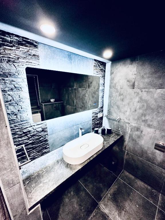 a bathroom with a white sink and a mirror at Trendy House 65 in Karácsond